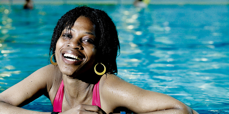 A black woman in a swimming pool smiling