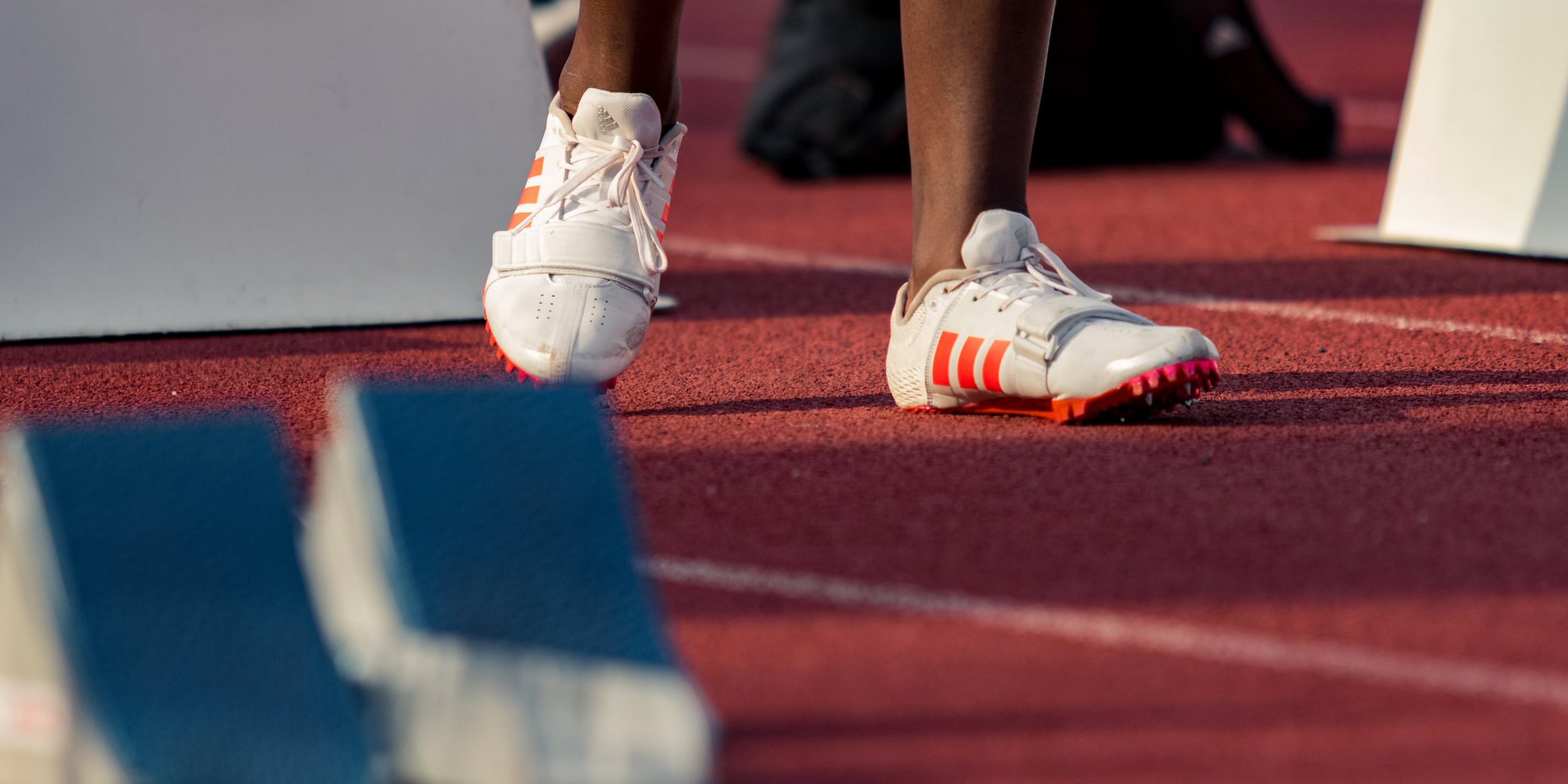 An athlete's feet wearing running spikes on an athletics track