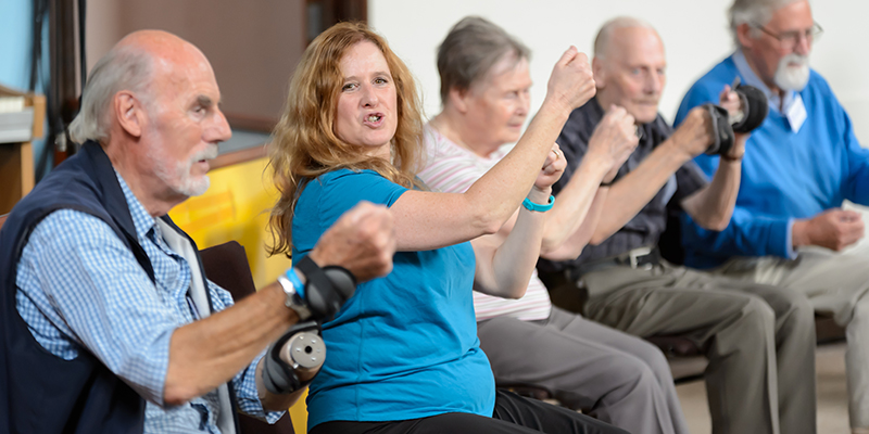 A group of older people in a seated exercise class