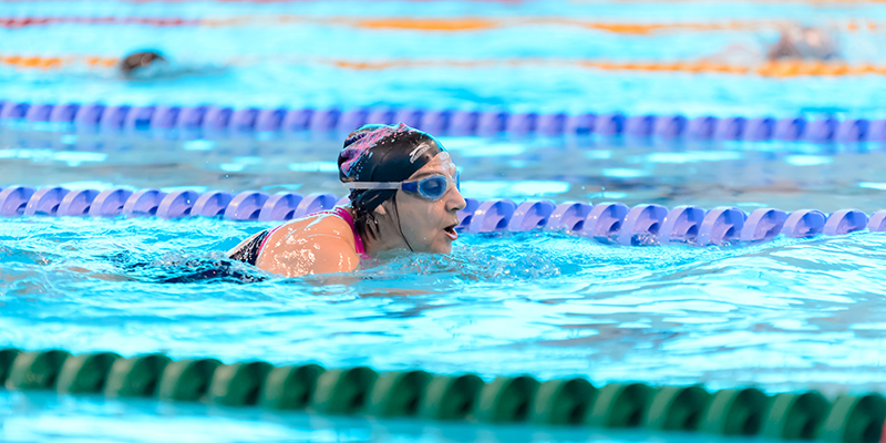 A woman swimming in a swimming pool lane