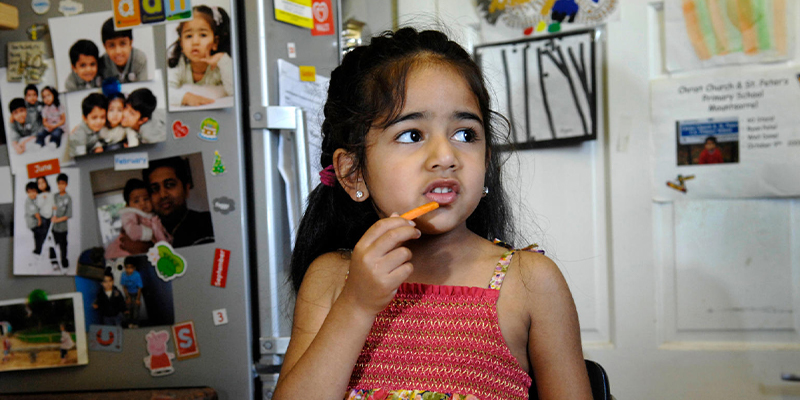 A young child eating a carrot