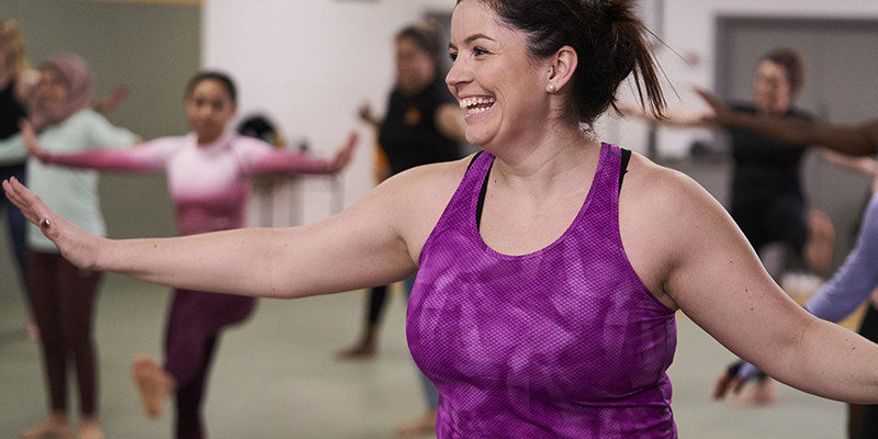 A woman smiling in a group exercise class