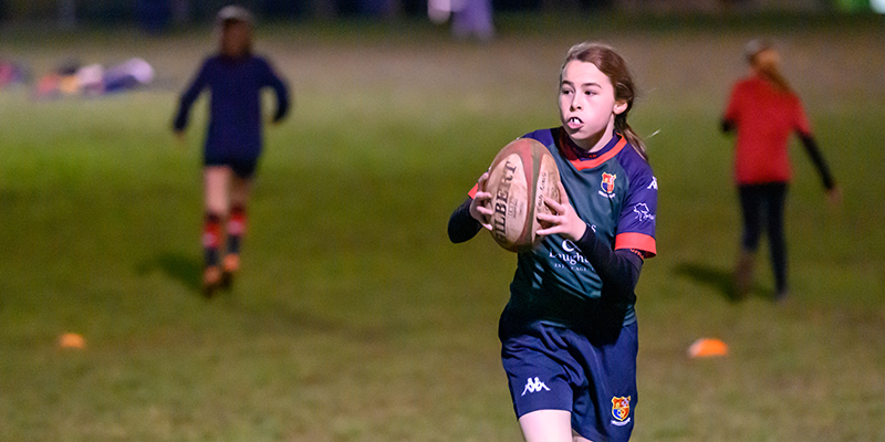 Young girl playing rugby