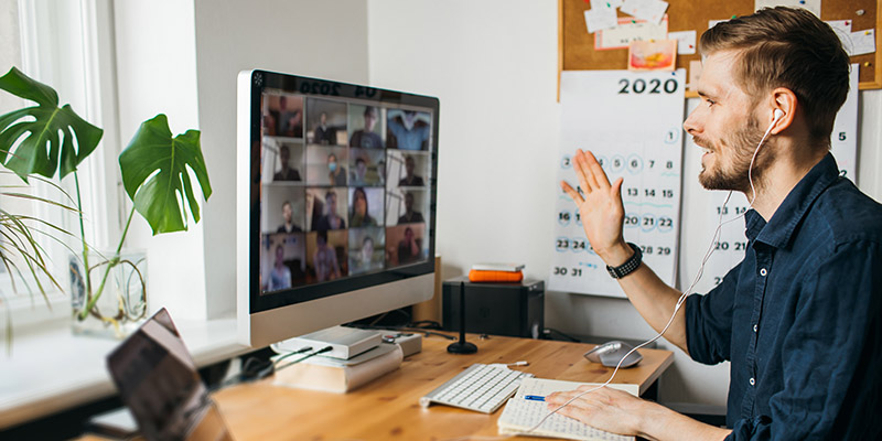 Young man having Zoom video call via a computer in the home office