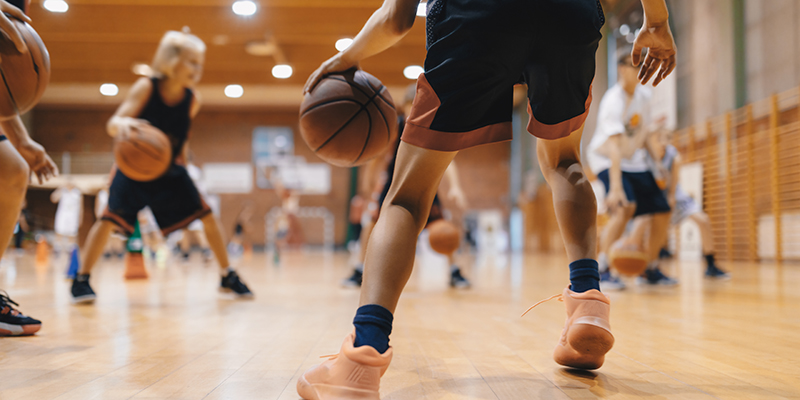 Junior level basketball player bouncing basketball