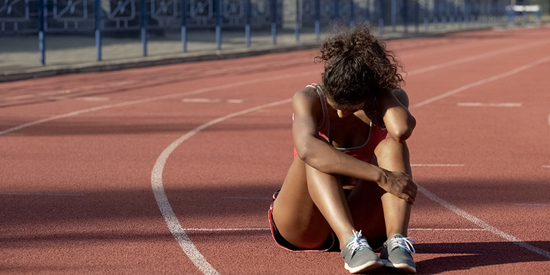 sportswoman upset sat on running track
