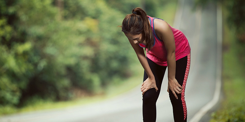 A women bent over looking tired from running